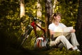 Young woman with bicycle in forest