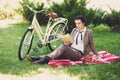 Young woman with bicycle having picnic in the park Royalty Free Stock Photo