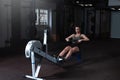 Young woman with big muscles doing hard core row heavy cross training workout Royalty Free Stock Photo