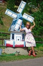 Young woman and a big toy flouring-mill Royalty Free Stock Photo