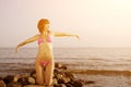 Young woman in bikini on beach with her his hands up. Girl with Royalty Free Stock Photo