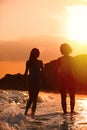 Young woman in bikini and her on beach at sunset. Lovely couple