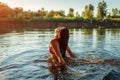 Young woman in bikini jumping out of water and making splash. Summer vacation Royalty Free Stock Photo