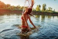 Young woman in bikini jumping out of water and making splash. Summer vacation Royalty Free Stock Photo