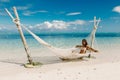 Young woman in bikini relax in hammock at tropical beach. Tropical vacations