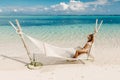 Young woman in bikini relaxing in hammock at beach. Tropical vacations at Mauritius Royalty Free Stock Photo