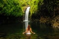 Young woman in bikini standing at Wainibau Waterfall on Taveuni