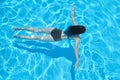 Young woman in bikini swimming underwater in an outdoor swimming pool, top view Royalty Free Stock Photo