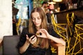 Young woman with a bitcoin and smartphone sits in a cafe Royalty Free Stock Photo