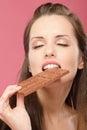 Young woman bites chocolate Royalty Free Stock Photo