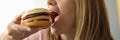 Young woman bites her mouth wide open hamburger Royalty Free Stock Photo
