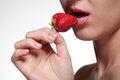 Young woman biting strawberry isolated on white Royalty Free Stock Photo