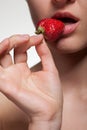 Young woman biting strawberry isolated on white Royalty Free Stock Photo