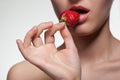 Young woman biting strawberry isolated on white Royalty Free Stock Photo