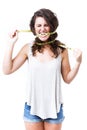 Young woman biting tape measure over white background.