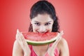 Young woman biting watermelon on red background Royalty Free Stock Photo