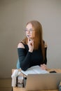 a young woman in a black blouse is doing freelance work in a cafe. female student at remote work