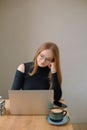 a young woman in a black blouse is doing freelance work in a cafe. female student at remote work