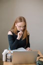 a young woman in a black blouse is doing freelance work in a cafe. female student at remote work