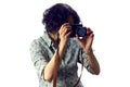 Young woman with black curly hair holding camera and making photos Royalty Free Stock Photo