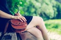 Summer in the park: Young woman in sexy black dress and ballerinas is sitting on a park bench