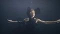 Young woman in black dress swimming underwater on dark background Royalty Free Stock Photo