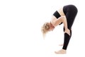 Young woman in black fitness attire doing stretching while standing. Isolated over white background. Space for text Royalty Free Stock Photo