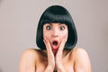 Young woman with black hair posing on camera. Amazed scared brunette with bob haircut look straight. Naked and isolated Royalty Free Stock Photo