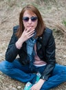 Young woman in a black jacket and jeans sitting on the hay Royalty Free Stock Photo