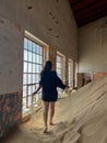 Young woman in black shirt and underwear in abandoned building posing in room.