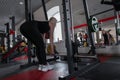 Young woman in black sportswear in great shape doing exercises with a metal fingerboard in a modern gym. Royalty Free Stock Photo