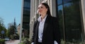 Young woman in a black suit looking to camera outside on street. Businesswoman portrait near office building. Royalty Free Stock Photo