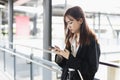 Young woman in black suit is using smartphone. Chatting. Online working. in public places. Female find information map location on Royalty Free Stock Photo