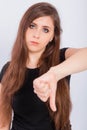 Young woman in black t-shirt showing thumb down gesture isolated on white background Royalty Free Stock Photo