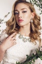 Young woman with blond curly hair wears elegant lace dress and bijou Royalty Free Stock Photo