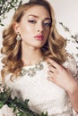 Young woman with blond curly hair wears elegant lace dress and bijou Royalty Free Stock Photo