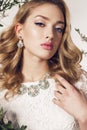 Young woman with blond curly hair wears elegant lace dress and bijou Royalty Free Stock Photo