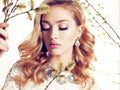 Young woman with blond curly hair wears elegant lace dress and bijou Royalty Free Stock Photo