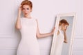 Young woman with blond hair in retro style,wears elegant white dress Royalty Free Stock Photo