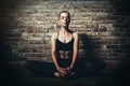 Young woman blond in black clothes practice yoga in dark studio Sport meditation