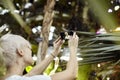 Young woman with blonde short hair is making selfie. Taking photo using phone camera in a green park. Focused on phone Royalty Free Stock Photo