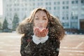 Young woman blow the snow from her hands. Royalty Free Stock Photo