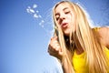 Young woman blowing dandelion Royalty Free Stock Photo