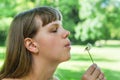 Young woman blowing dandelion flower Royalty Free Stock Photo