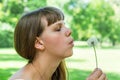 Young woman blowing dandelion flower Royalty Free Stock Photo