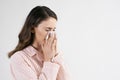 Young woman blowing her nose in studio shot Royalty Free Stock Photo