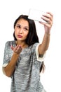 Young woman blowing kiss while taking selfie Royalty Free Stock Photo