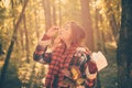 Young woman blowing nose at nature. Sick people has runny nose. Woman with allergy symptoms blowing nose.