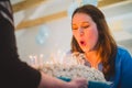 Young woman blowing out candles Royalty Free Stock Photo