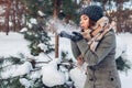 Young woman blowing snow in winter forest. Girl having fun outdoors Royalty Free Stock Photo